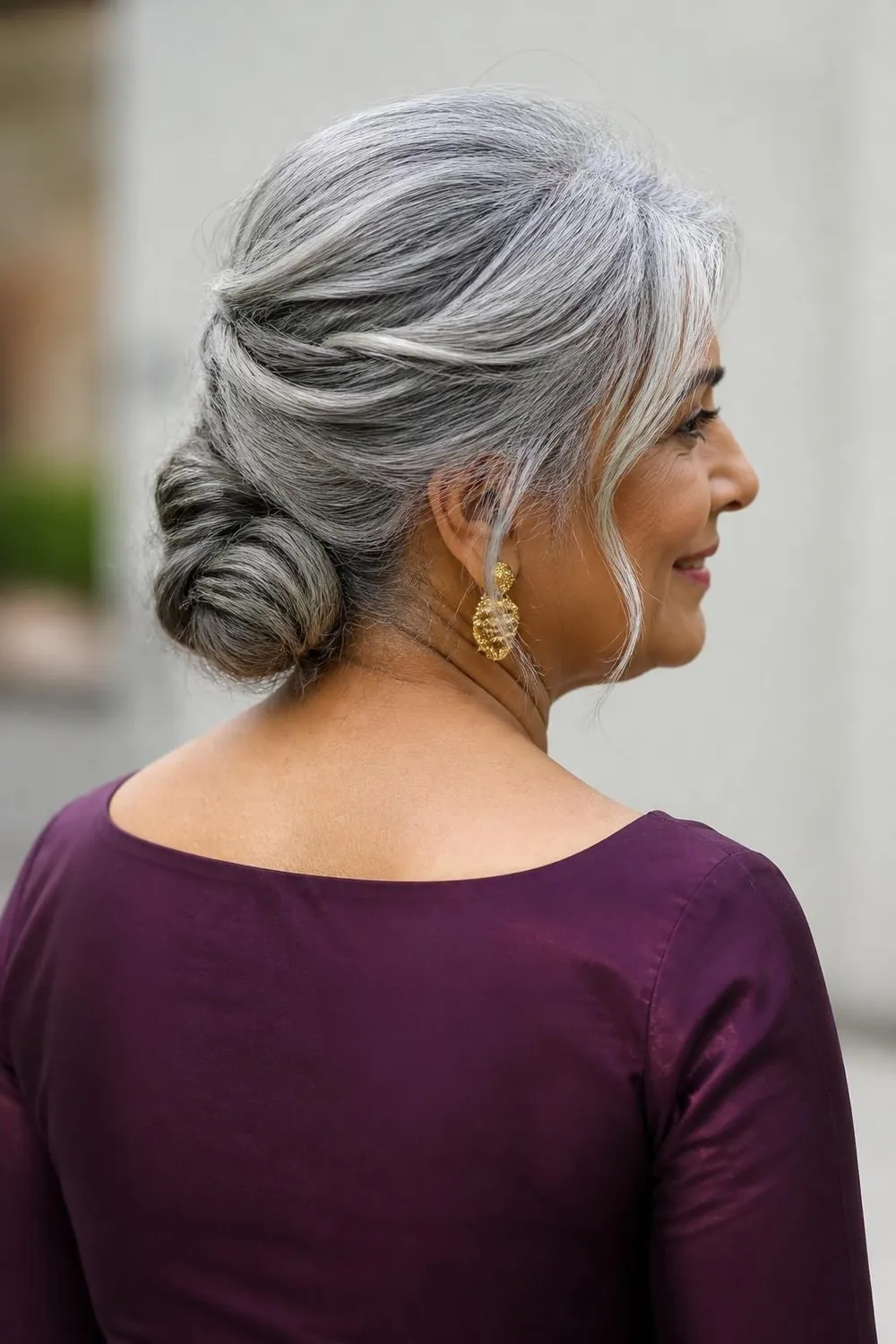 Low silver chignon at the nape with soft face-framing strands