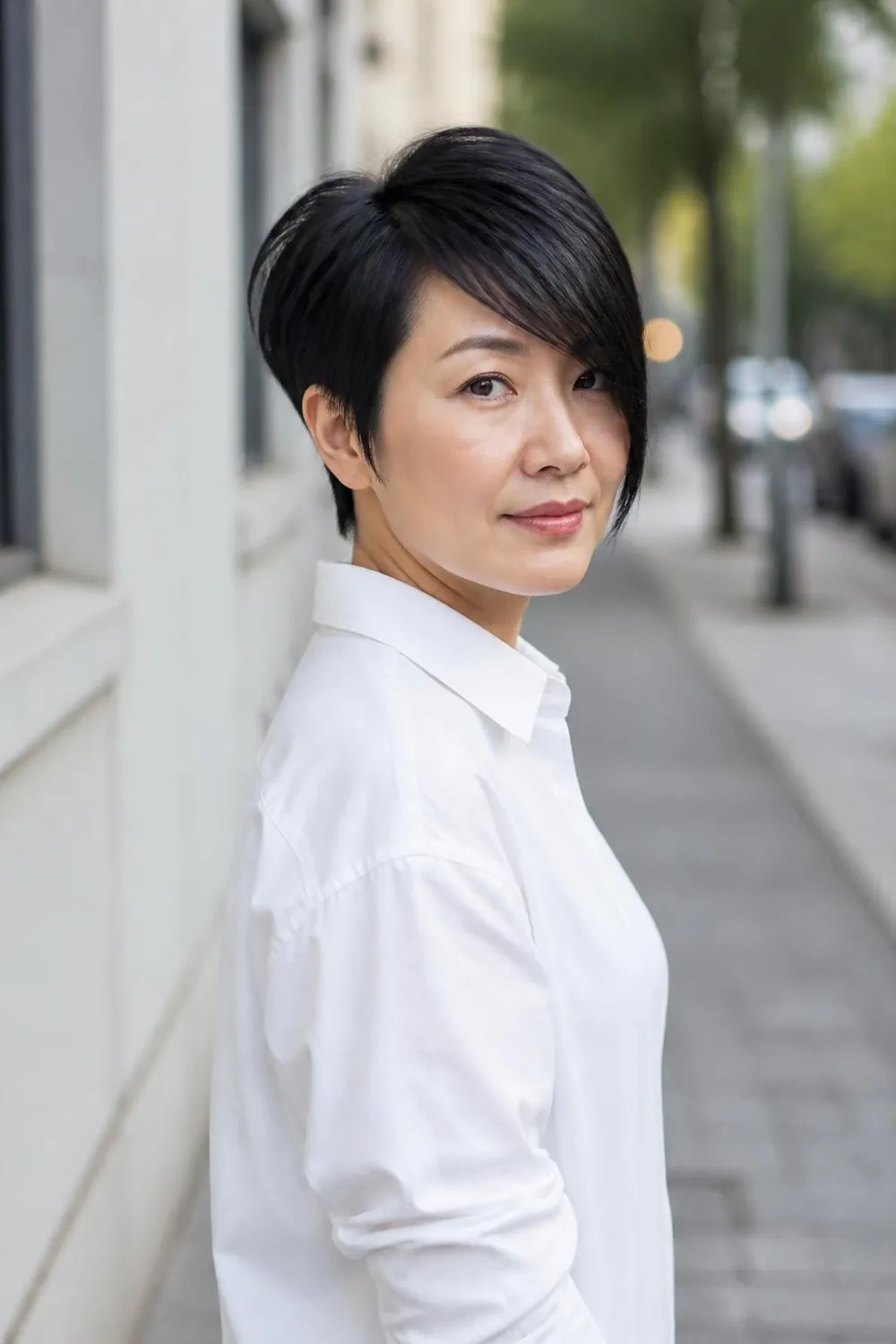 Long side-swept pixie with a deep part for a round face in her 40s