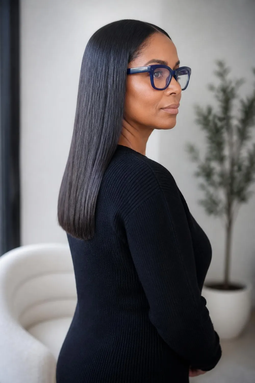 Long blunt one-length cut tucked behind one ear with bold blue glasses