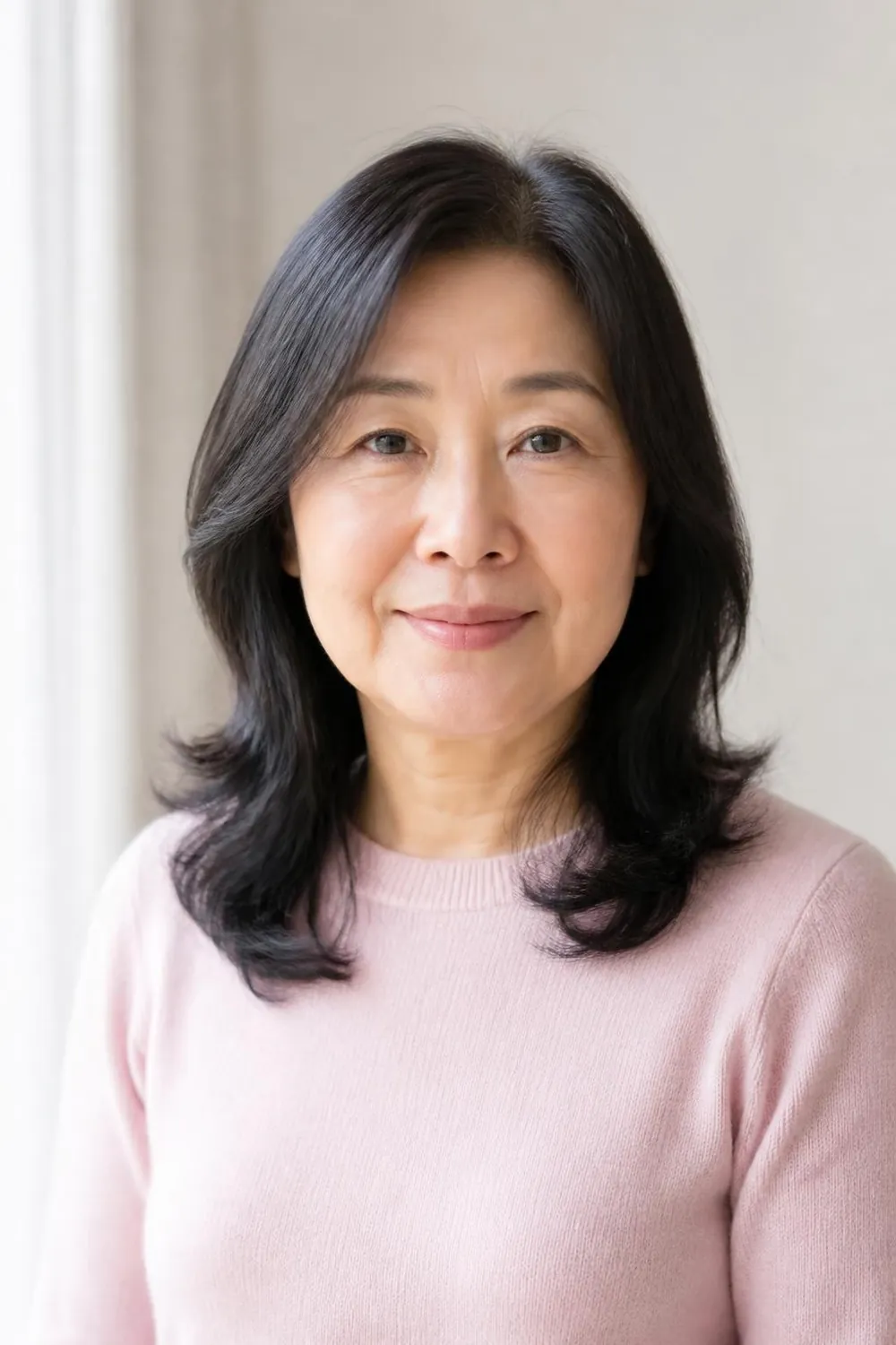 Shoulder-length layers beginning below the chin for a woman over 50 with a round face