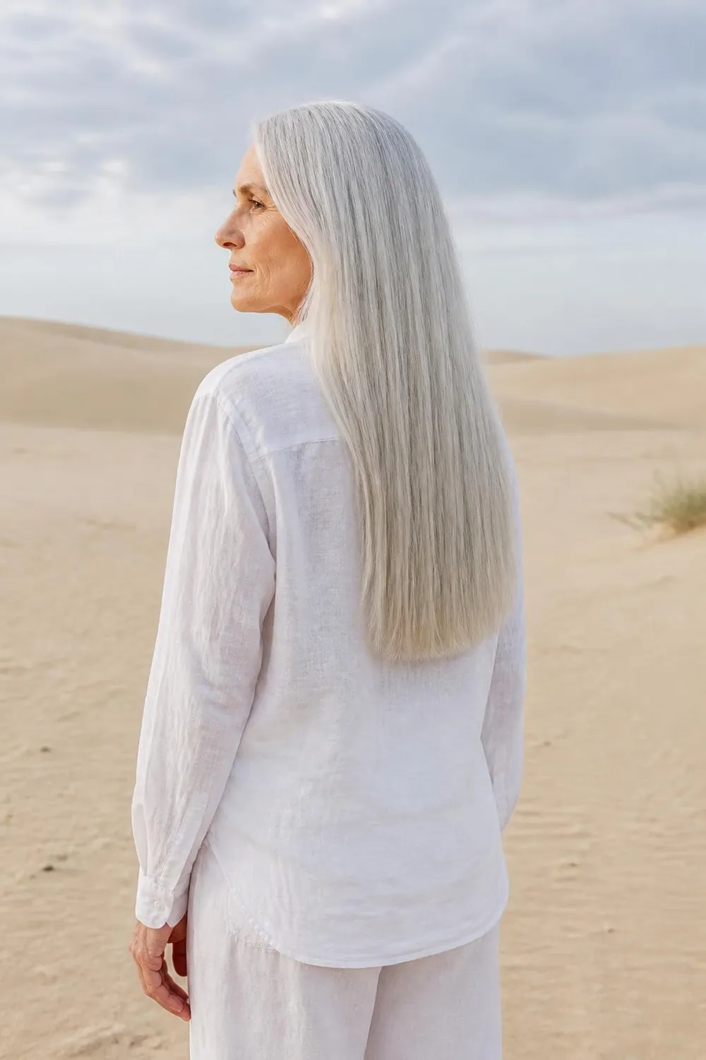 Long silver hair with blunt ends and a middle part on a woman over 60