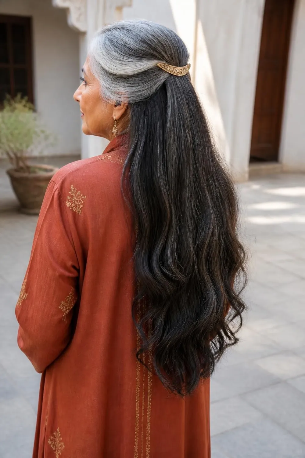 Long hair in a half-up style with a gold barrette, woman in her 60s