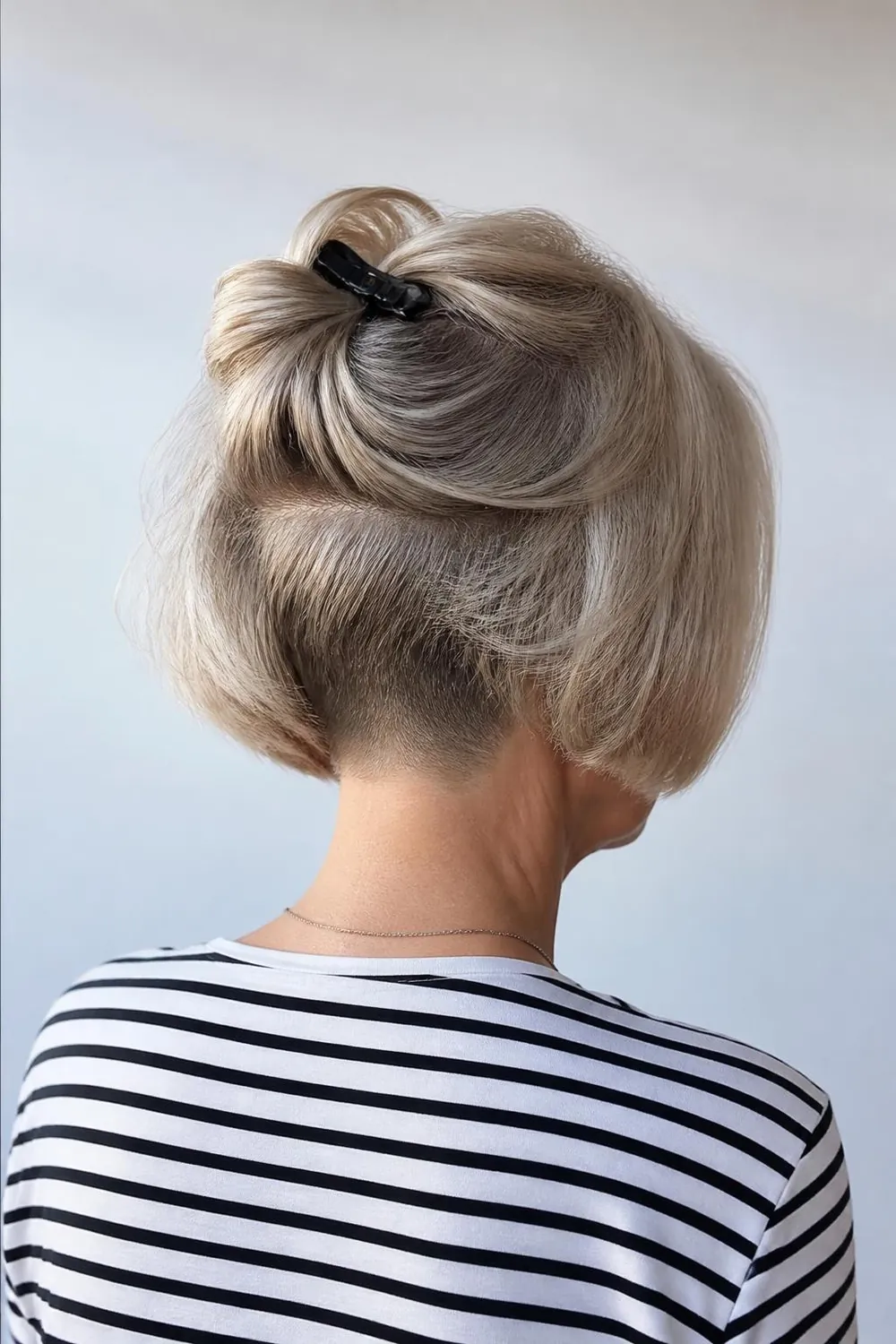 Bob with a hidden undercut at the nape shown with hair lifted, woman over 60