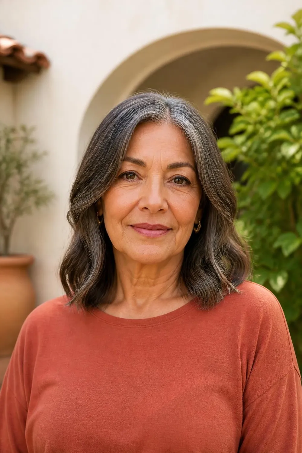 Center-parted wavy lob just past the shoulders on a Latina woman in her 60s