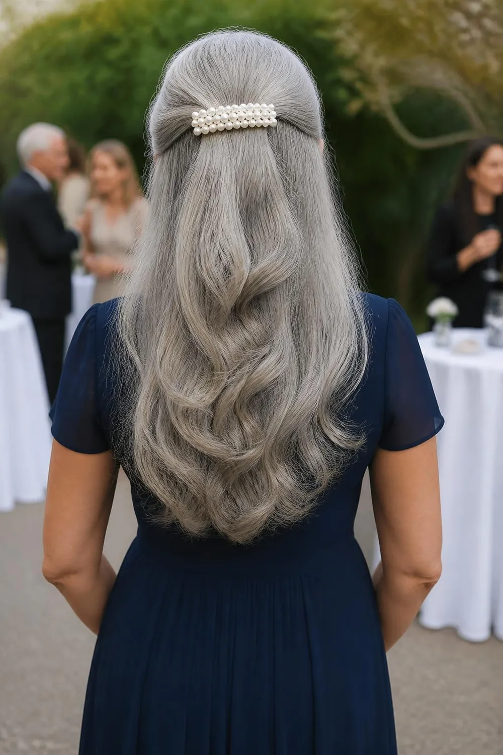 Long silver hair in a half-up style held with a large pearl barrette