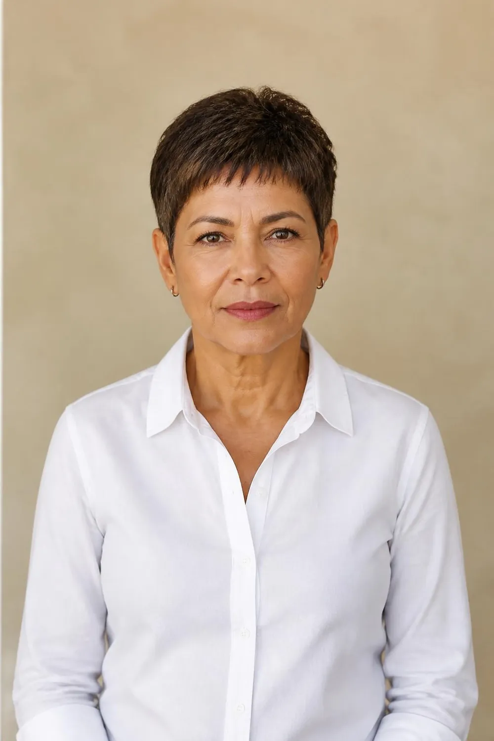 Caesar style pixie with a short textured fringe brushed forward on a woman over 50