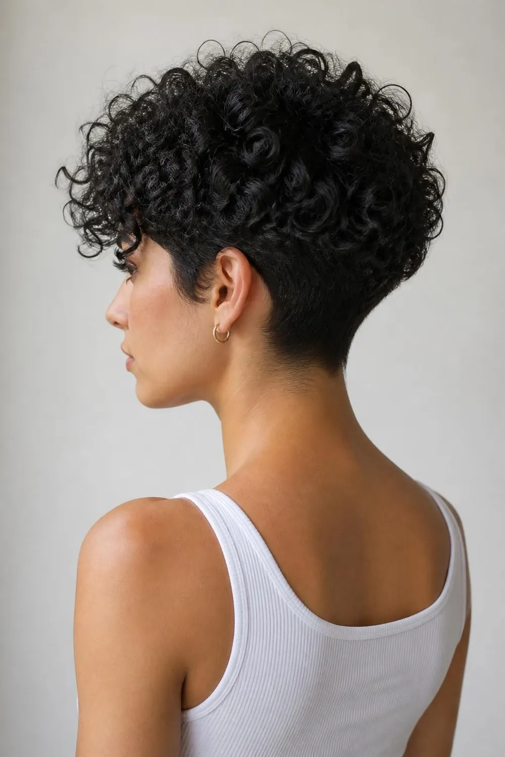 Curly pixie with a clipped nape and defined curls on top for 3B to 3C hair